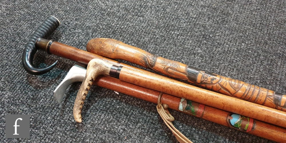 A Japanese bamboo walking stick carved with warriors, another with and aluminium pick axe handle and