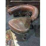 A 19th Century mahogany library elbow chair, with a crescent shaped back rail over carved scroll