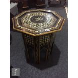 A Moorish ebonised and inlaid octagonal occasional table, diameter 48cm and a similar carved