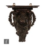A 19th/20th Century carved oak wall bracket, the apostle and acanthus leaves forming the lower
