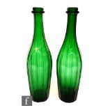 A pair of 20th Century green glass decanters of bottle form, each with faceted decoration, lacking
