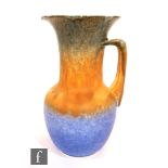 A Ruskin Pottery crystalline glaze jug decorated in a mottled blue to orange to blue, impressed mark