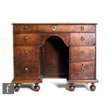 An 18th Century and later oak kneehole writing desk, fitted with an arrangement of seven drawers