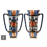 A pair of late 19th Century Macintyre & Co twin handled vases each decorated in a design by