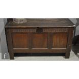 An 18th Century oak coffer with a triple fielded panel front over stile feet.