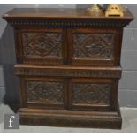 A 17th Century style carved oak court cupboard enclosed by a double pair of doors on a lunette