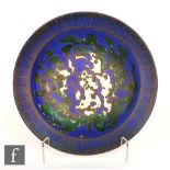 A Gouda charger decorated in green and blue with and abstract design with mustard detailing, painted