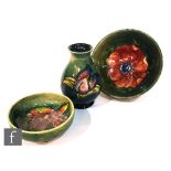 Three pieces of Moorcroft Pottery comprising a small Freesia pattern baluster vase, height 9cm, a