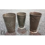 Three Art Nouveau secessionist pewter tumbler vases each decorated in relief, to include a