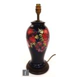 A Moorcroft Pottery table lamp decorated in the Anemone pattern with tubelined flowers against a