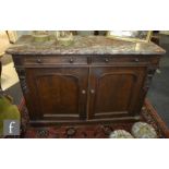 A Victorian carved dark oak two door sideboard on a plinth base, with brown veined marble top,