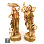 A pair of Royal Dux figures of a male and female Persian water carriers, each with applied