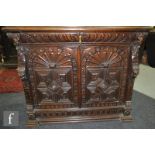 A late Victorian carved oak sideboard, the single frieze drawer over a fan burst and geometric