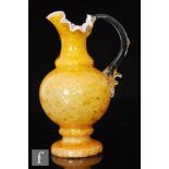 A late 19th Century glass jug of footed form with wave rim, ochre with graduated bronze to gold