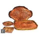 An early 19th Century Arts & Crafts copper tray of oval form with roll rim and radial decoration,
