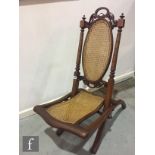 A 19th Century folding steamer chair, with oval cane back on, sabre legs.