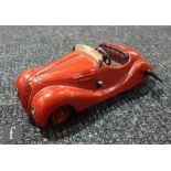 A Schuco Examico 4001 tinplate clockwork car in red with maroon seats, windscreen and key, with