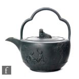 A 19th Century Wedgwood black basalt tea kettle decorated with applied scenes of cherubs playing and