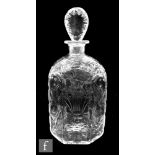 A spirit decanter of compressed flat cut form, decorated with stylised floral sprays formed from