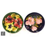 Two Moorcroft Pottery plates, the first decorated in the Hibiscus pattern with tubelined flowers