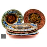 A collection of six Palissy style terracotta dishes, each with the border edge decorated with