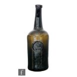 A late 18th Century olive green glass wine bottle of mallet form with applied lip and an applied '