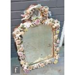 A large late 19th to early 20th Century Dresden type mirror heavily decorated with applied encrusted