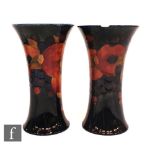 A pair of Moorcroft trumpet vases decorated in the Pomegranate pattern, both with a band of open and