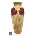 An early 20th Century Royal Doulton vase of tapering form with a flared collar neck decorated with