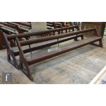 A long pine pew with iron bar support and prayeror hymn book shelf, shaped open ends, height 88cm
