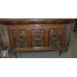An 18th century style carved oak triple panelled