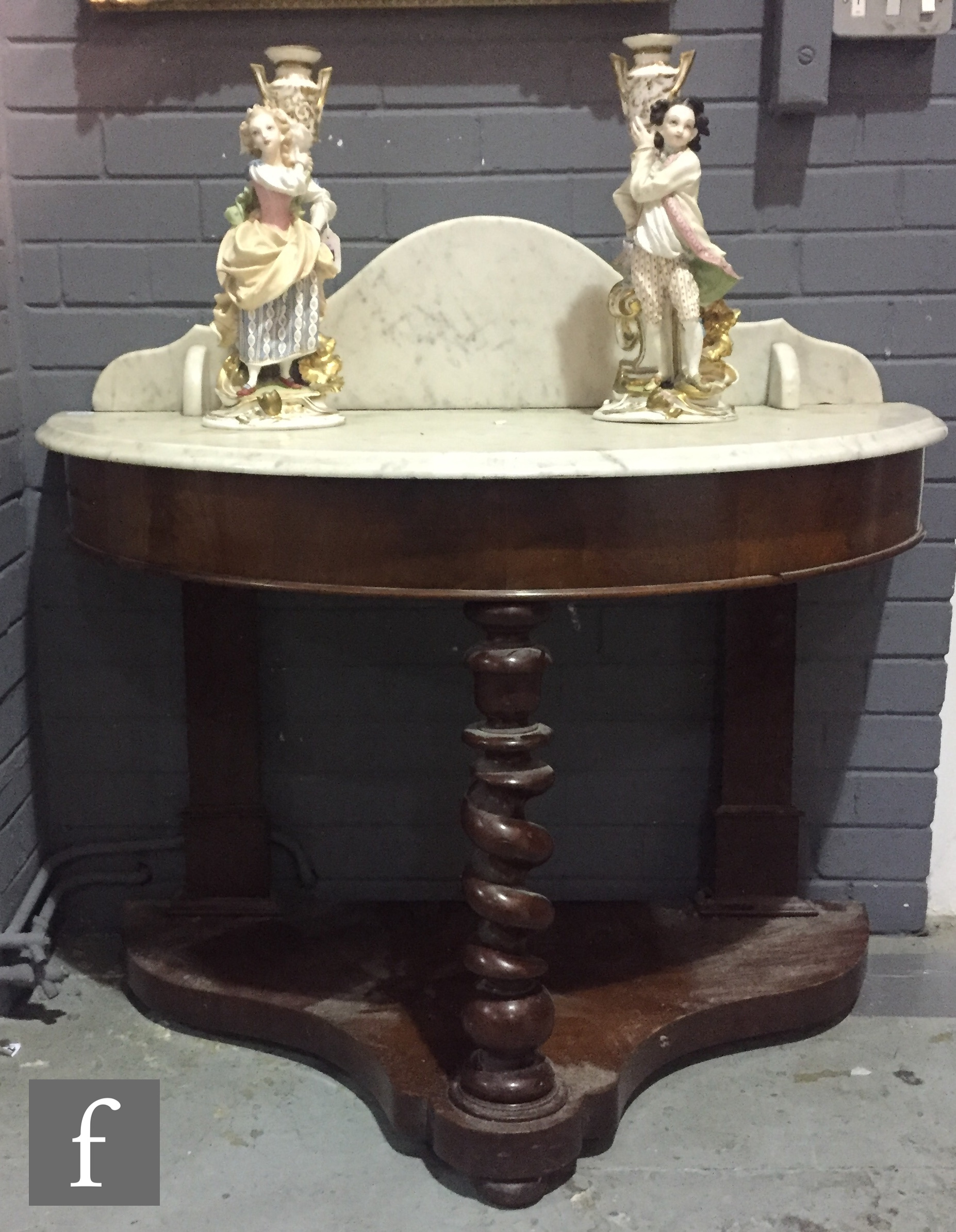 A Victorian mahogany demi-lune marble top washstand with spiral central support on a platform