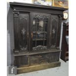 A large dark oak display cabinet fitted with a centre shelf enclosed by a beaded glazed door flanked