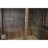 A large 18th Century and later oak cupboard enclosed by a pair of arched doors over a plain base,