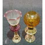 A small Victorian brass oil lamp and shade with ruby reservoir on ring turned and foliate base,