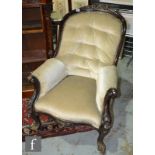 A Victorian spoonback armchair, with a foliate carved top crest over scroll detailed capitals and