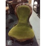 A 20th Century French fauteille walnut elbow chair upholstered in green plush, on cabriole legs