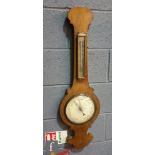 A 19th Century walnut wheel barometer incorporating a thermometer, height 92.5cm.