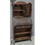 A Victorian carved oak combination bureau bookcase, the cupboard over a fall and single frieze
