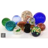 A selection of glass paperweights with various internal decoration, including stylised flowers, a