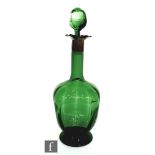 A late 19th Century Stevens and Williams green glass decanter of footed dimpled ovoid form with
