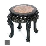 A 19th Century carved padouk wood jardiniere stand with rouge marble inset top over a pierced