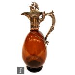 A late 19th to early 20th Century continental amber glass claret jug of footed ovoid form, in silver