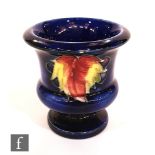 A small Moorcroft urn decorated in the Leaf and Berry pattern, impressed mark, height 7.5cm.