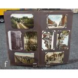 An Edwardian postcard album containing photographic cards, scenic views, greetings etc.