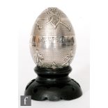 A Russian silver Easter egg with engine turned and part engraved foliate details with Christ is