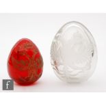 A Russian red glass Easter egg carved and gilded with a Romanov eagle, length 7cm, with a similar