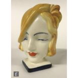 A 1930s Art Deco napkin ring formed as a ladies head upon a square base with ring to the back, faint