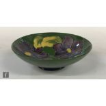 A Moorcroft shallow footed dish decorated in the Clematis pattern with tubelined flowers against a