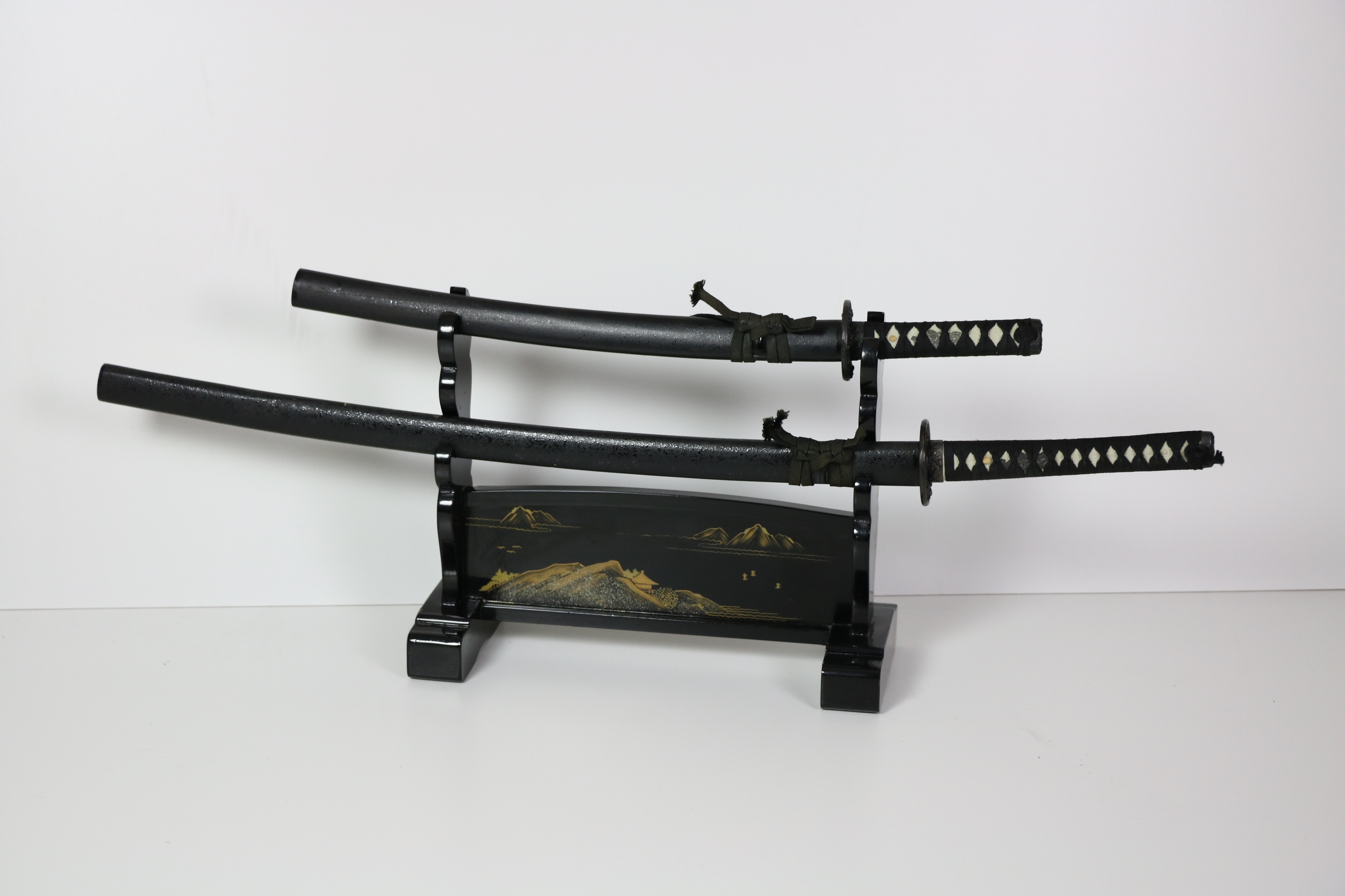 A modern black Japanese Katana Stand, with gilt decoration, and with two Japanese Katana Swords,